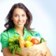 Portrait of pretty girl with big paper sack full of different fruits and vegetables